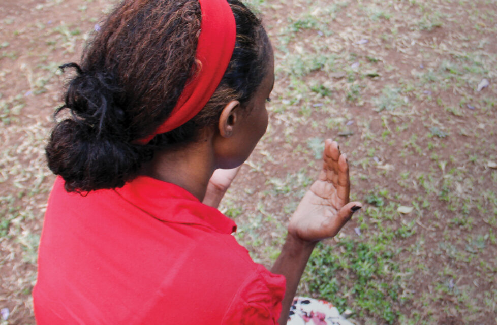 Daily Threats “Normal” for Christian Convert in Kenya A woman kneeling and praying