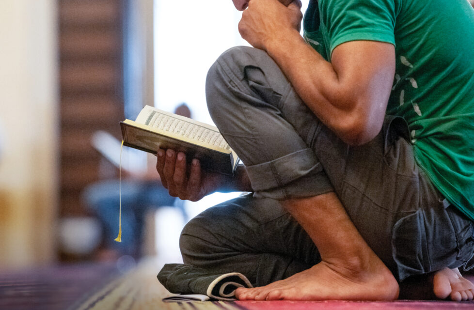 Former Islamic Scholar Attacked with Stones For Christian Faith man kneels while he reads the Bible