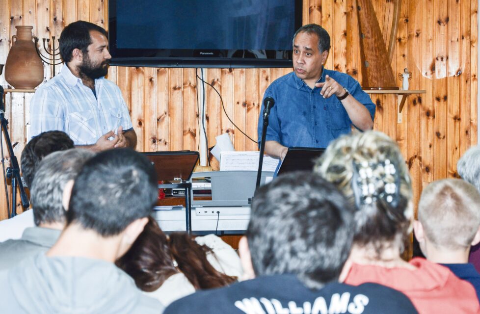 Tortured by the Palestinian Authority in the Holy City a man stands in front of a group of people at church and preaches