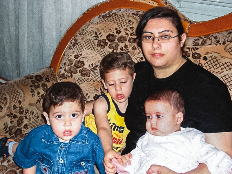 Christian Widows, Orphans Remaining Faithful After Attacks a picture of Pauline and her three children sitting on a couch
