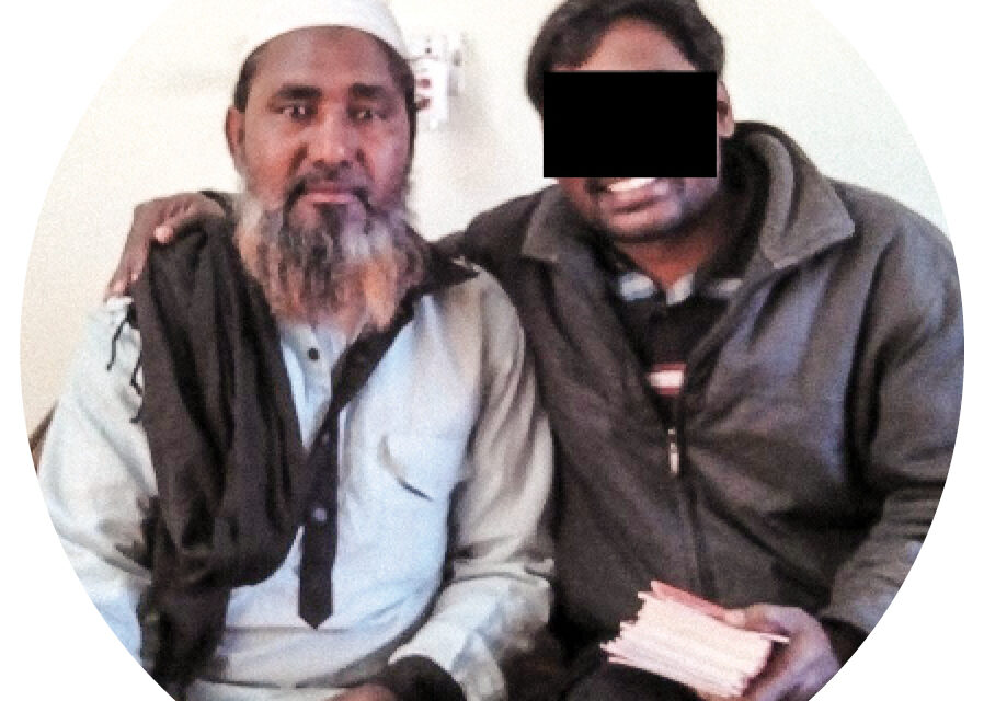 Indian Christians Beaten by Hindu Militants Two men sitting together smiling and one has a black box over his eyes and is holding a bible