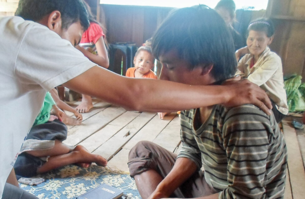 Prepared for Persecution: Our Heritage a man prays over a boy in church